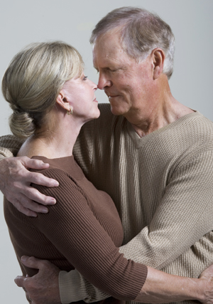 Hombre mayor y mujer mayor abrazándose.