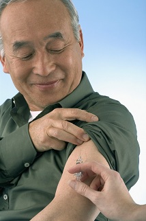 Man with sleeve rolled up, getting a shot
